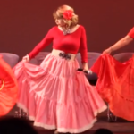 A trio of women in red dresses dancing