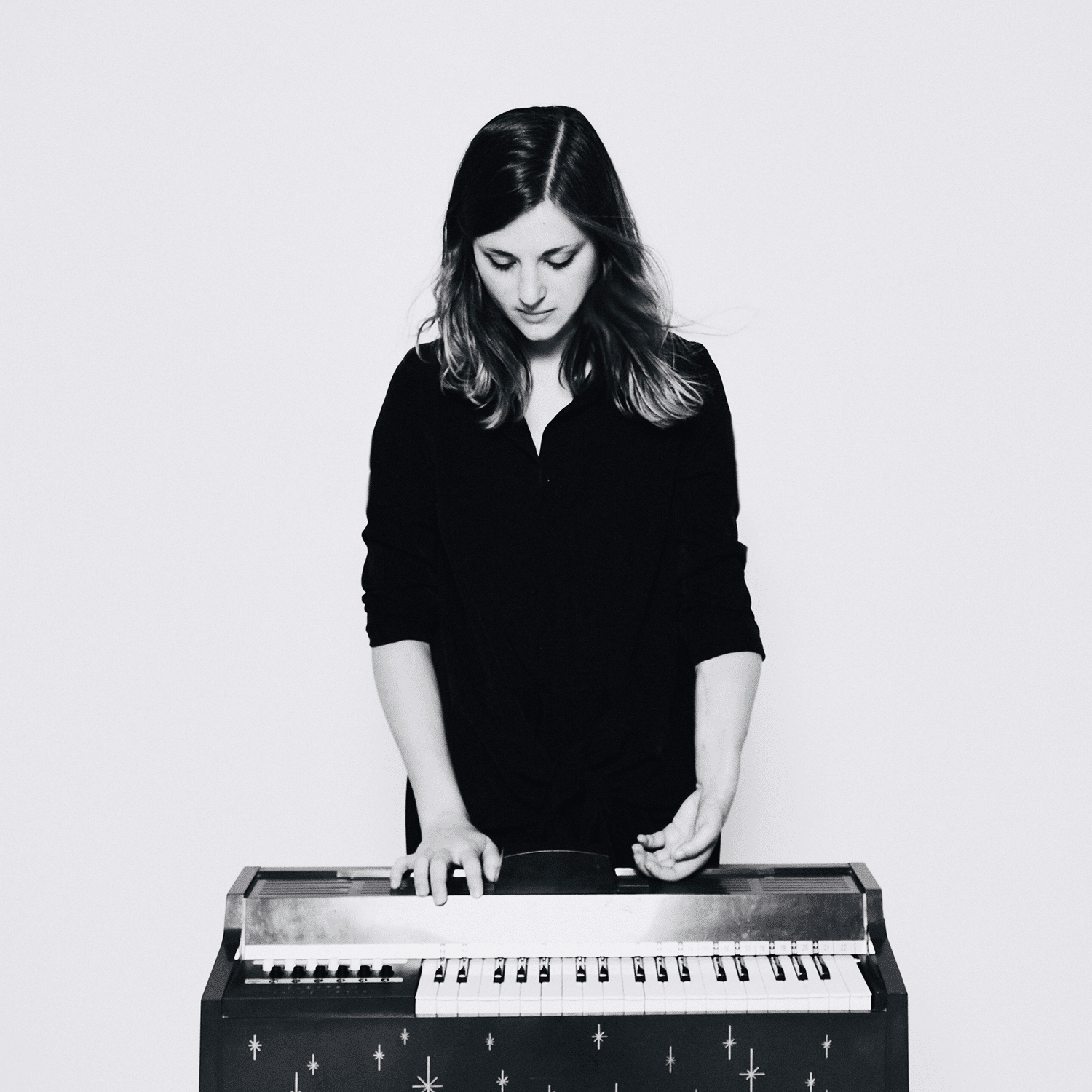 Photo of Molly Joyce standing behind the keyboard of a musical instrument