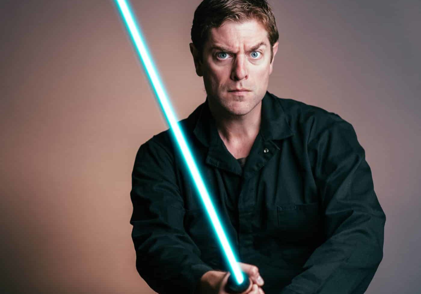 Photo of Charles Ross holding a light saber